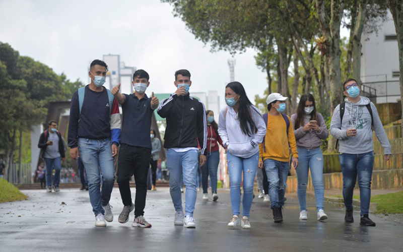 Photo showing students entering university and wearing face masks.