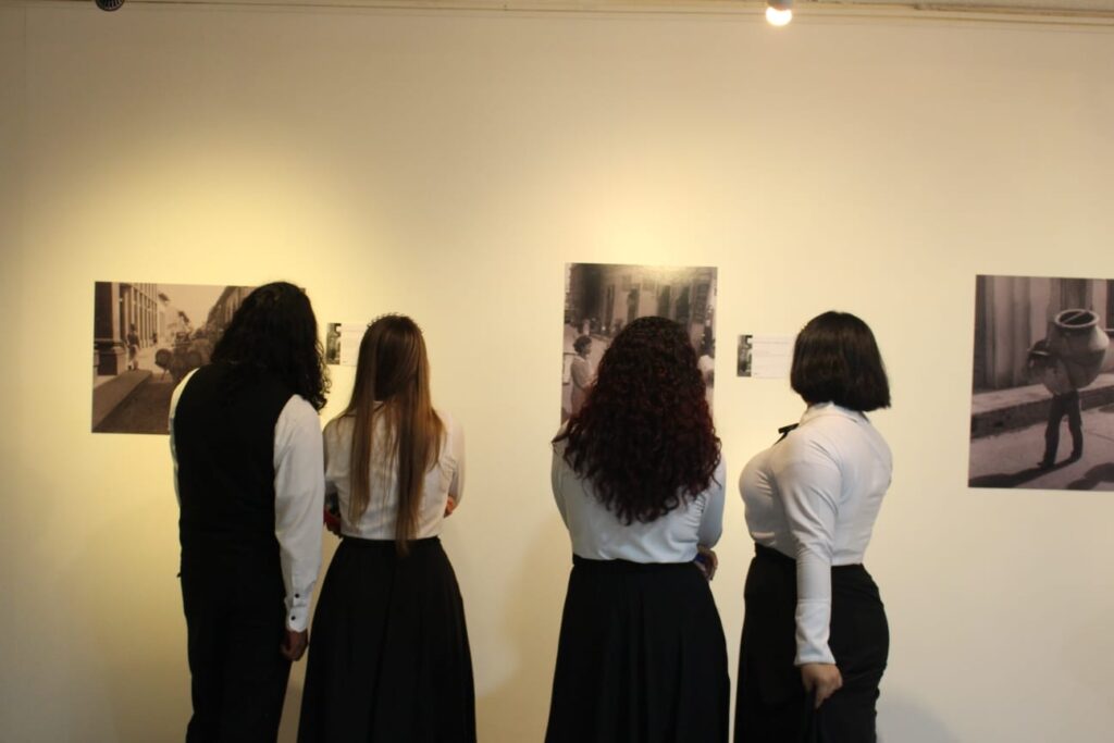 Imagen que muestra a los asistentes viendo las fotografías de la exposición
