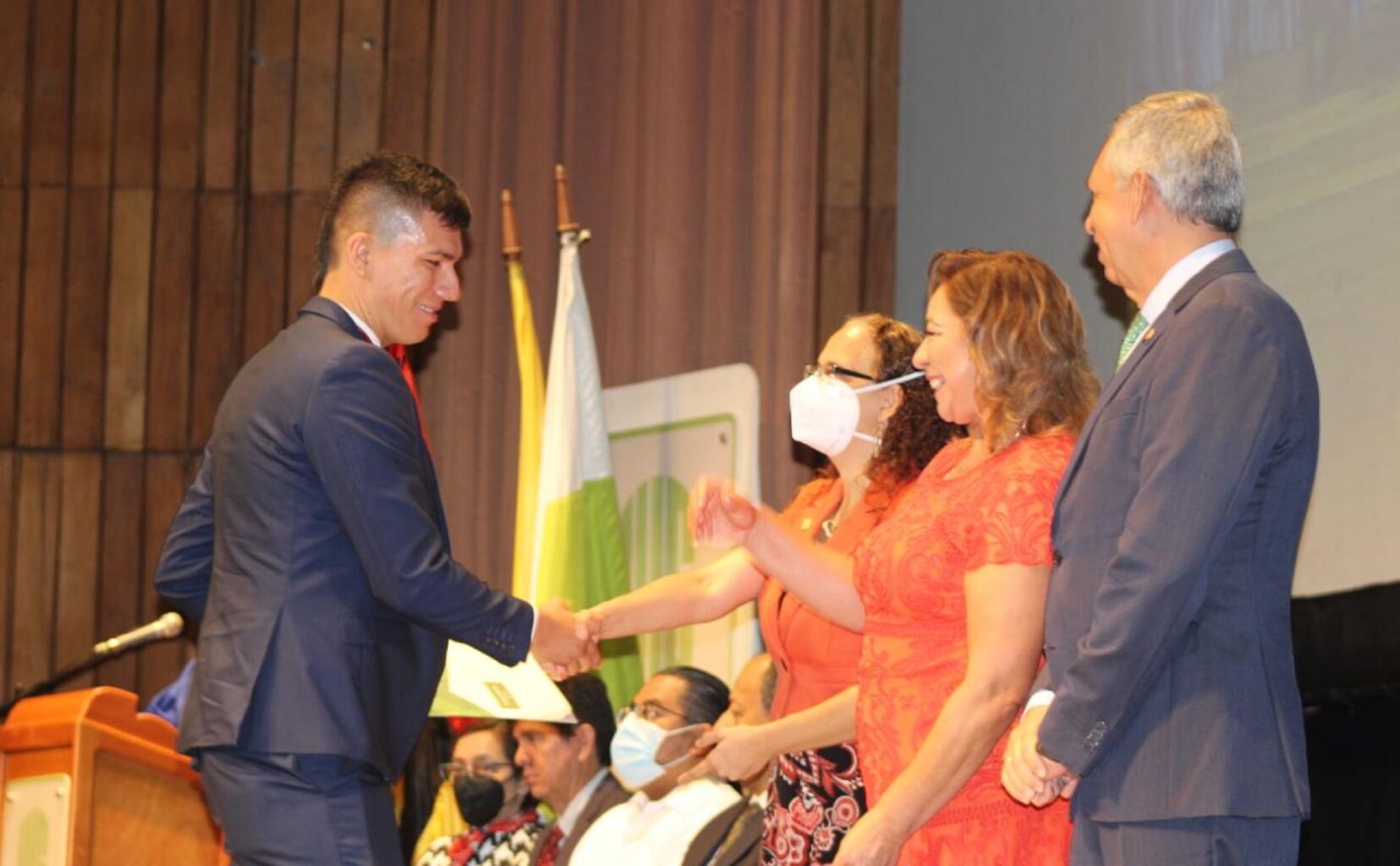 Imagen muestra a miembros del Consejo Académico felicitando a uno de los graduandos.