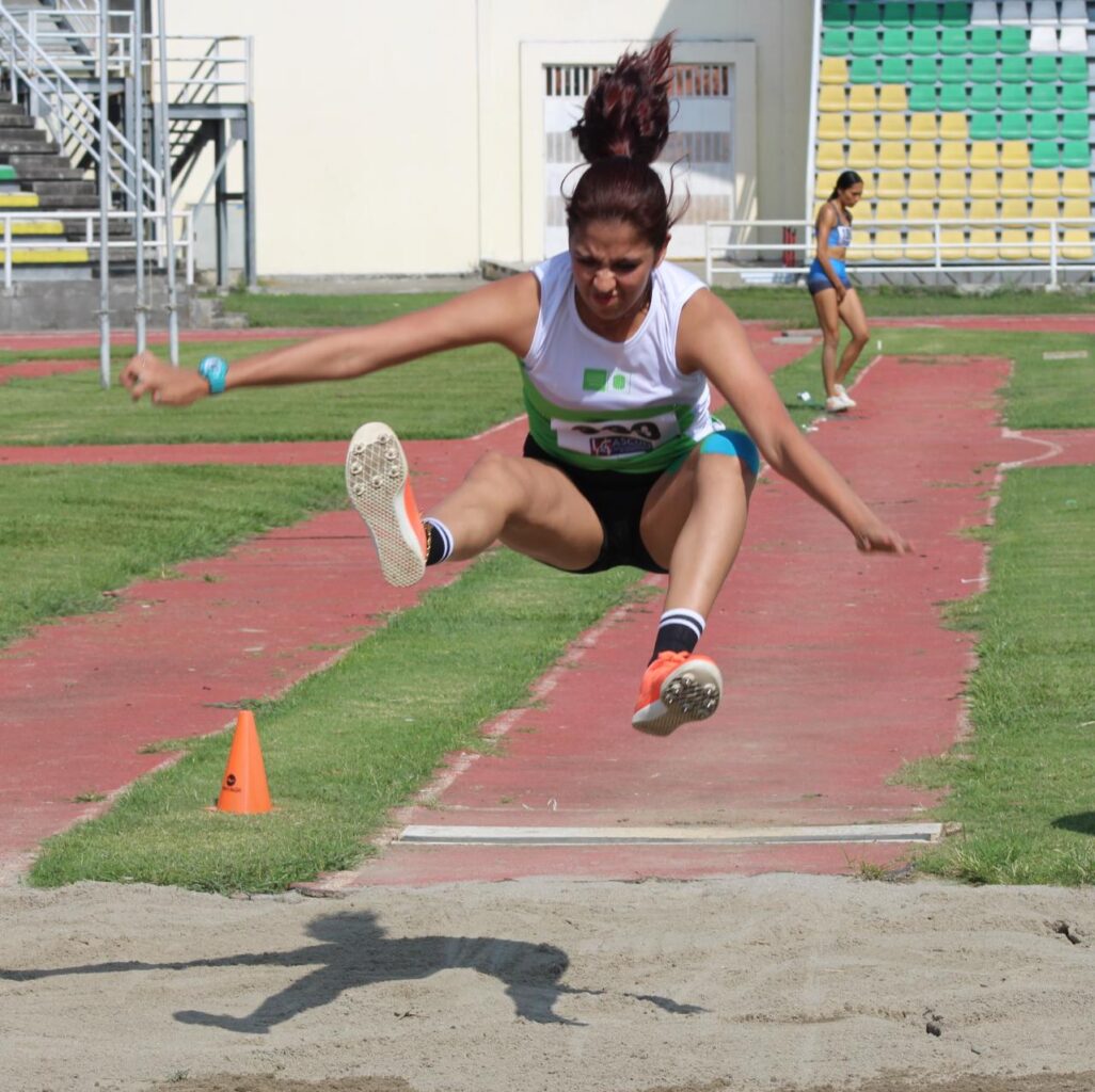 Imagen muestra atleta de la UIS efectuando el salto largo.