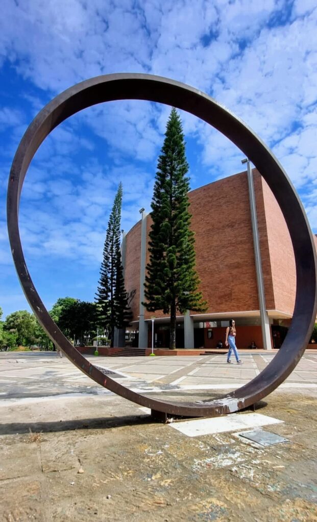 Monumento Lección de geometría en la UIS con el fondo de la fachada del auditorio Luis A. Calvo