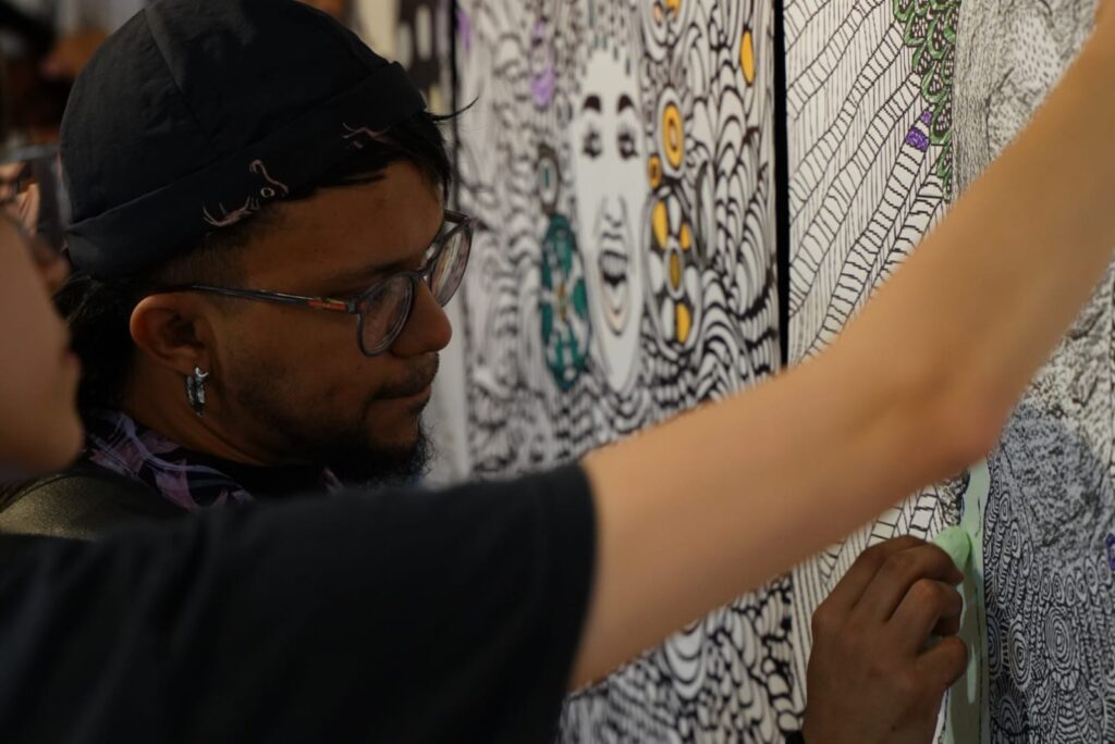 Detalle de estudiante interactuando con la obra como parte de la dinámica de la exposición.