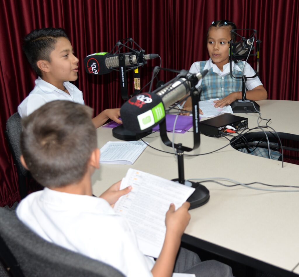 Estudiantes en cabina durante la grabación del programa radial Paidópolis.