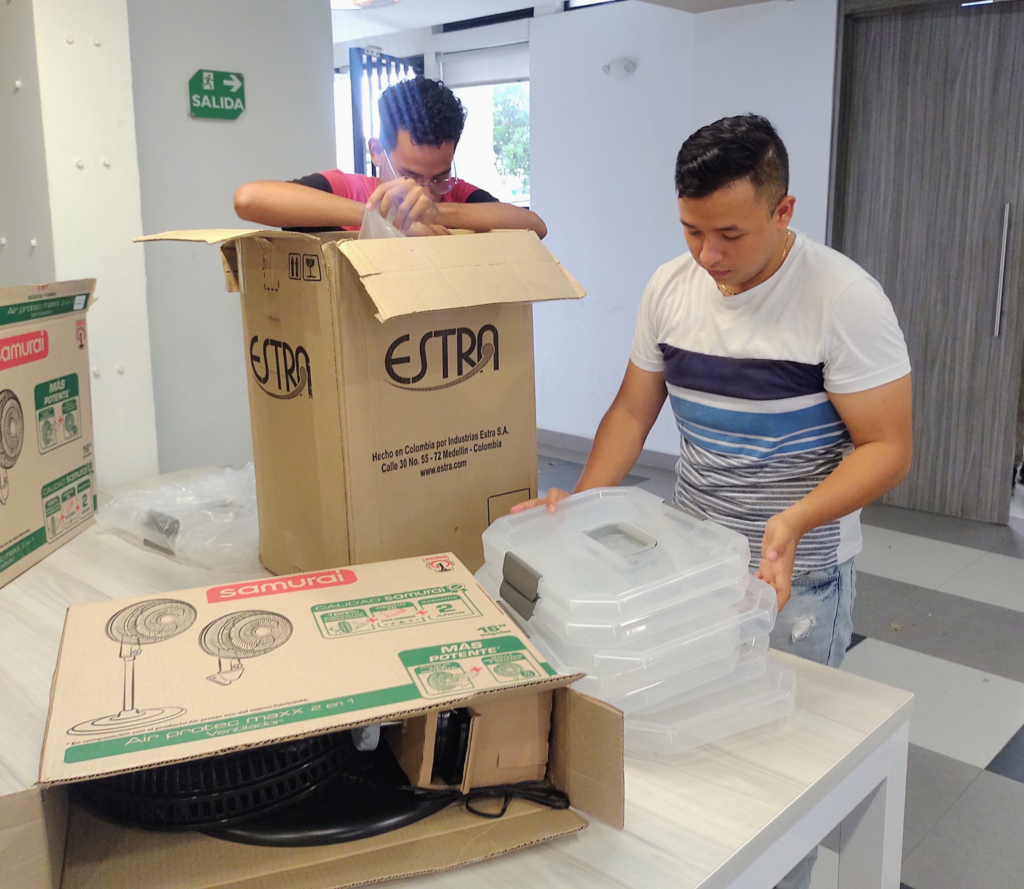 Estudiantes de la residencias universitarias sede 1, abriendo los utensilios de cocina recibidos por la Coordinación de Servicios de Alimentación de Bienestar Estudiantil 