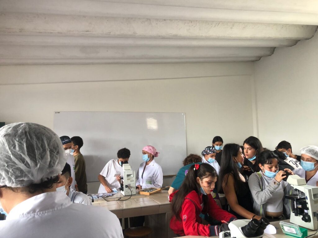 Estudiantes en salón de clase con telescopio