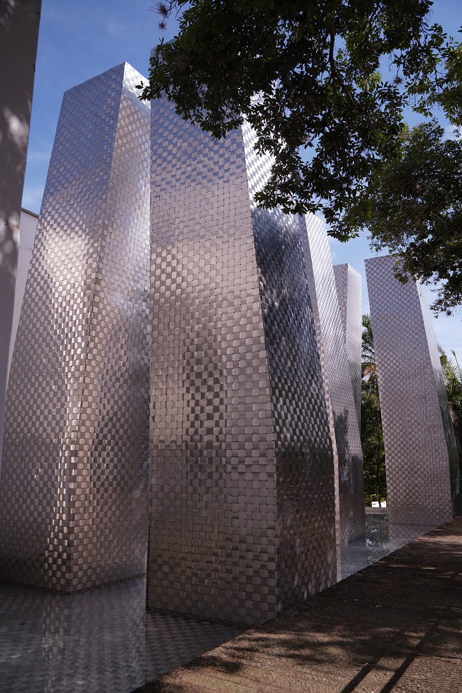 El reflejo de las láminas de acero reflejan el entorno arborizado dela escultura Sietenario.