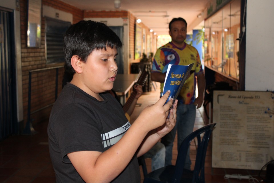 Joven participando en la novena de aguinaldo