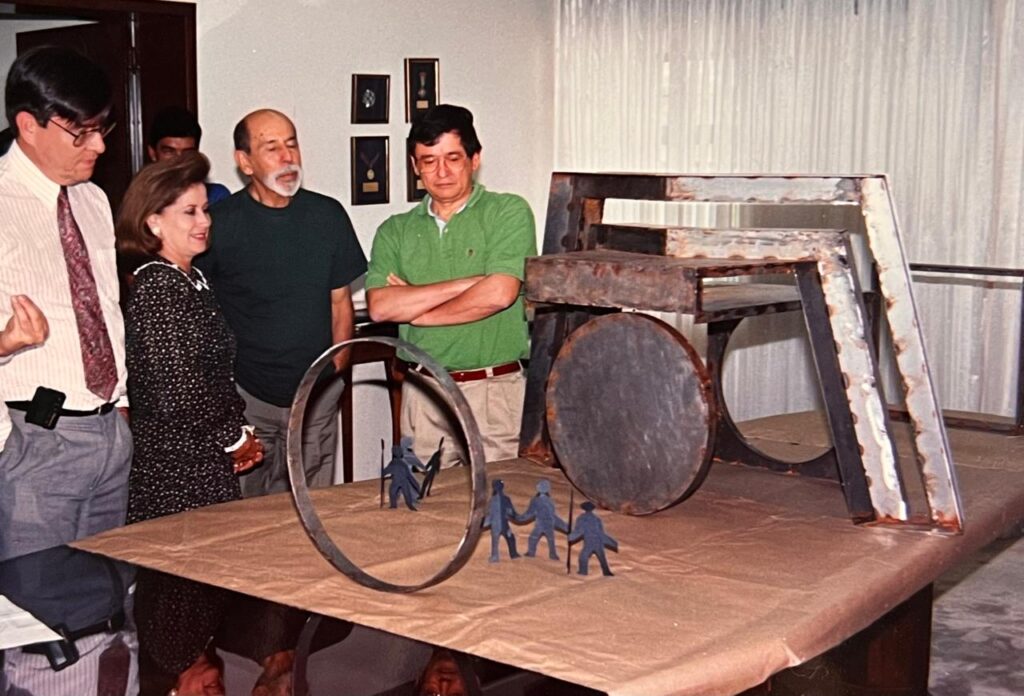 El artista mostrando la maqueta de su obra, entre otros, al rector Jorge Gómez Duarte.