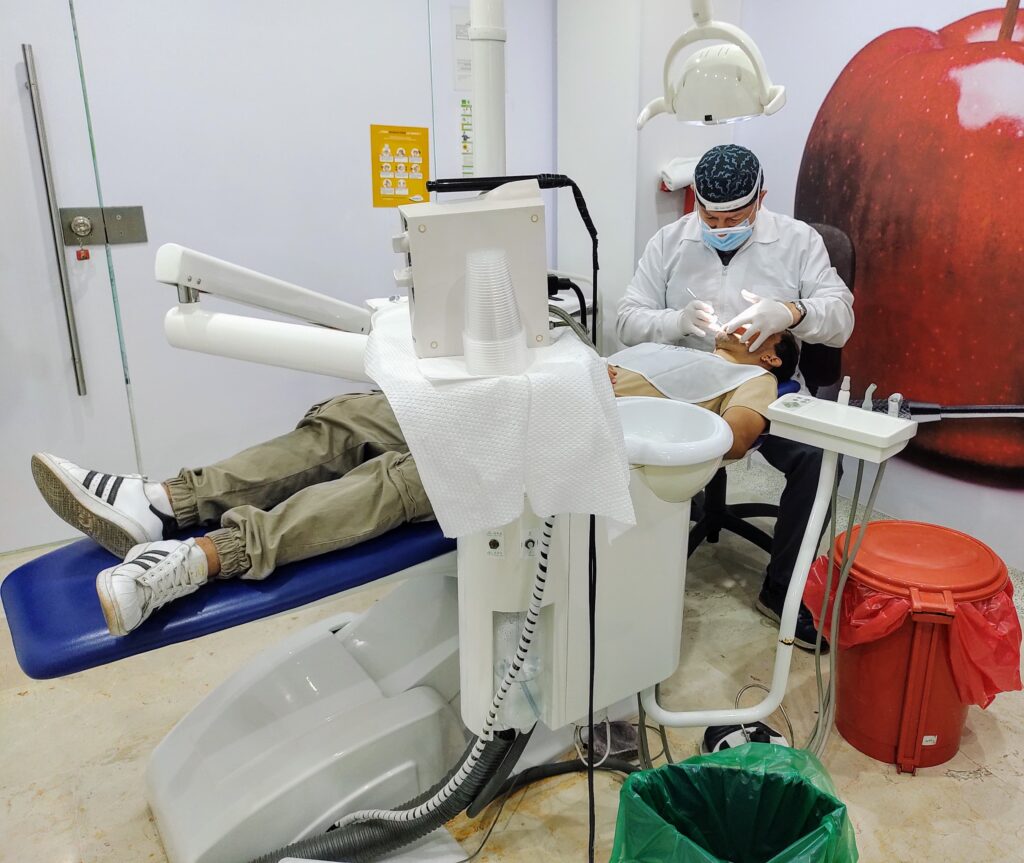 Estudiante en un examen odontológico, realizado por un profesional de la salud de Bienestar Estudiantil. 