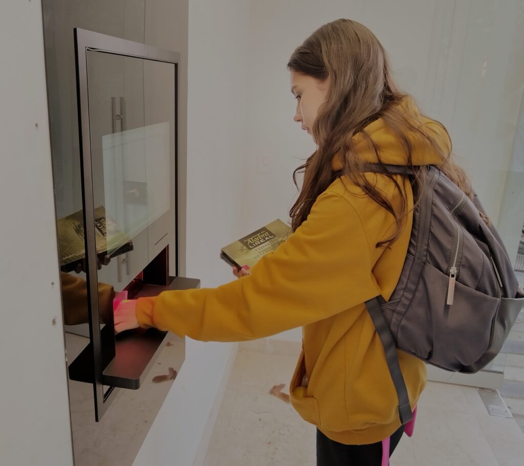 UIS student using the Central Library's new self-checkout equipment. 