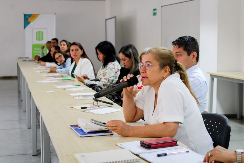 Rectora habla por micrófono mientras los asistentes escuchan.