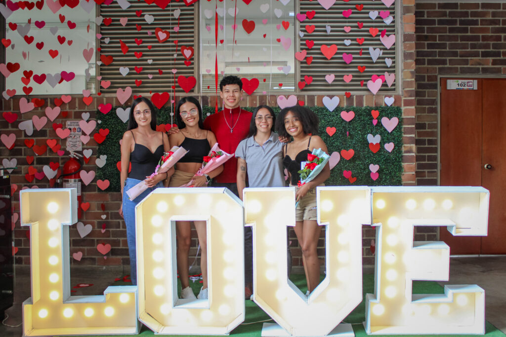 Estudiantes posan en el stand de fotografía dispuesto para la Feria de San Valentín 
