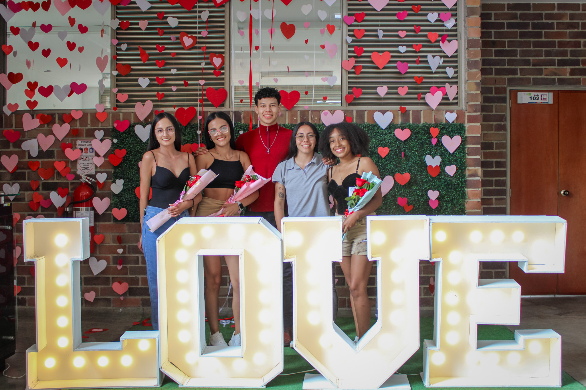 Estudiantes posan en el stand de fotografía dispuesto para la Feria de San Valentín