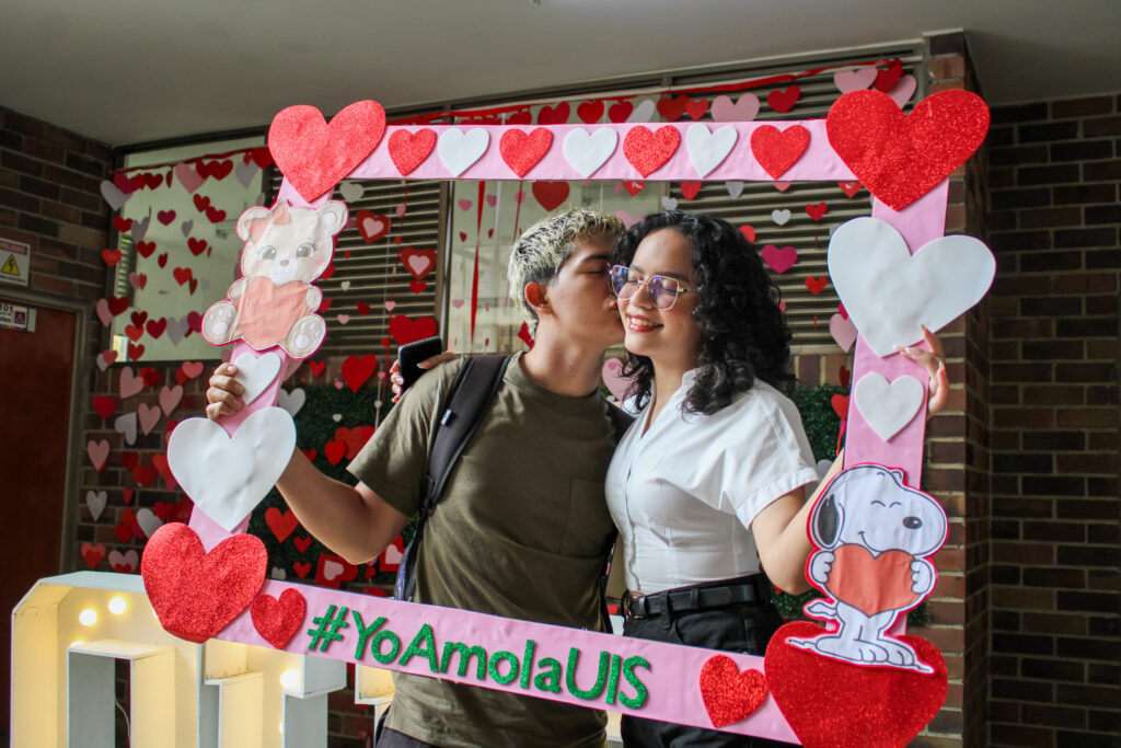 Estudiantes posan con el marco para fotografías de San Valentín 