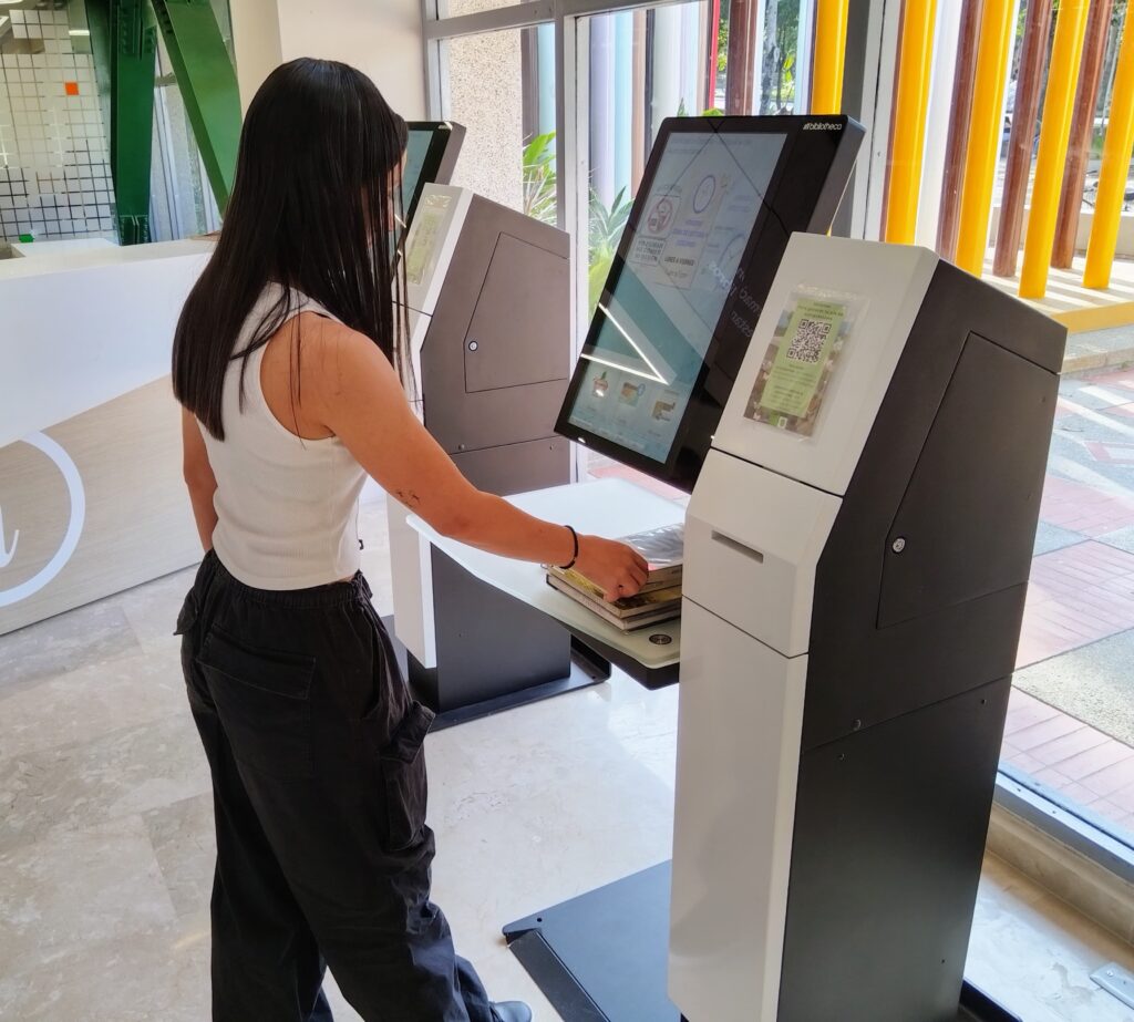 Estudiante UIS haciendo uso del equipo de autopréstamo de la Biblioteca Central.