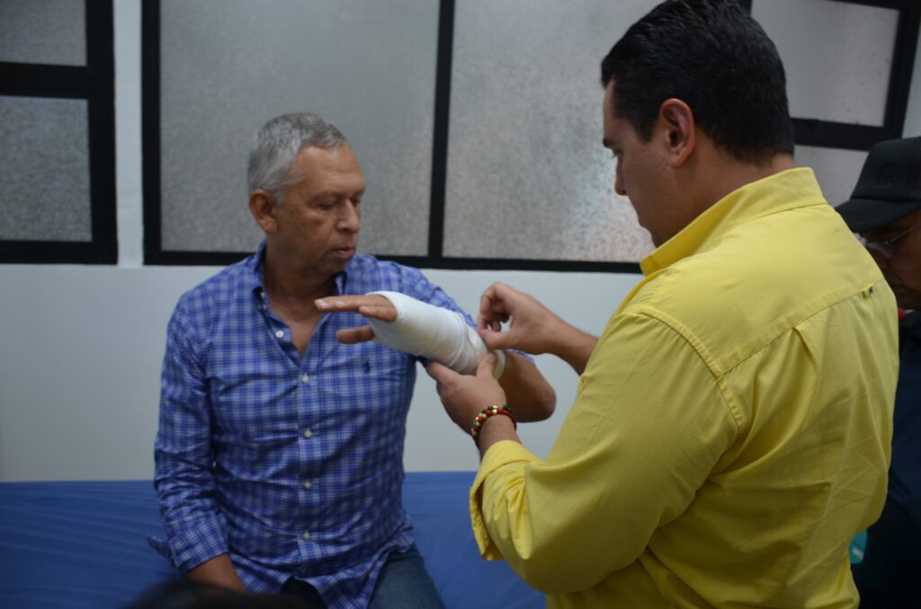 Médico de USALUD retirando vendaje al rector.