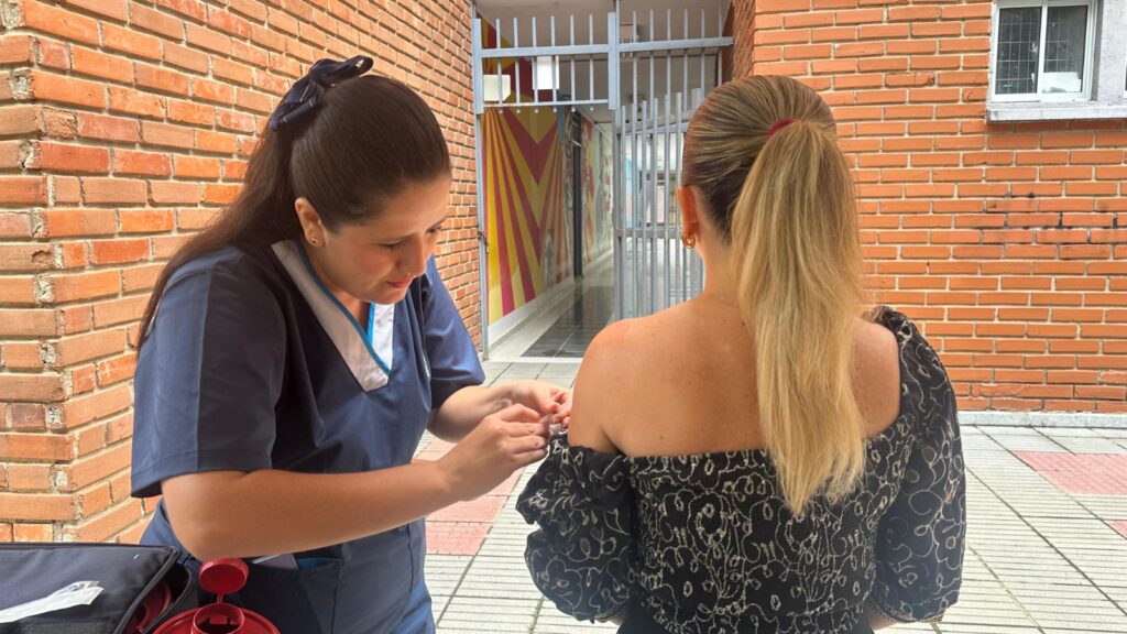 Enfermera aplicando vacuna a usuaria