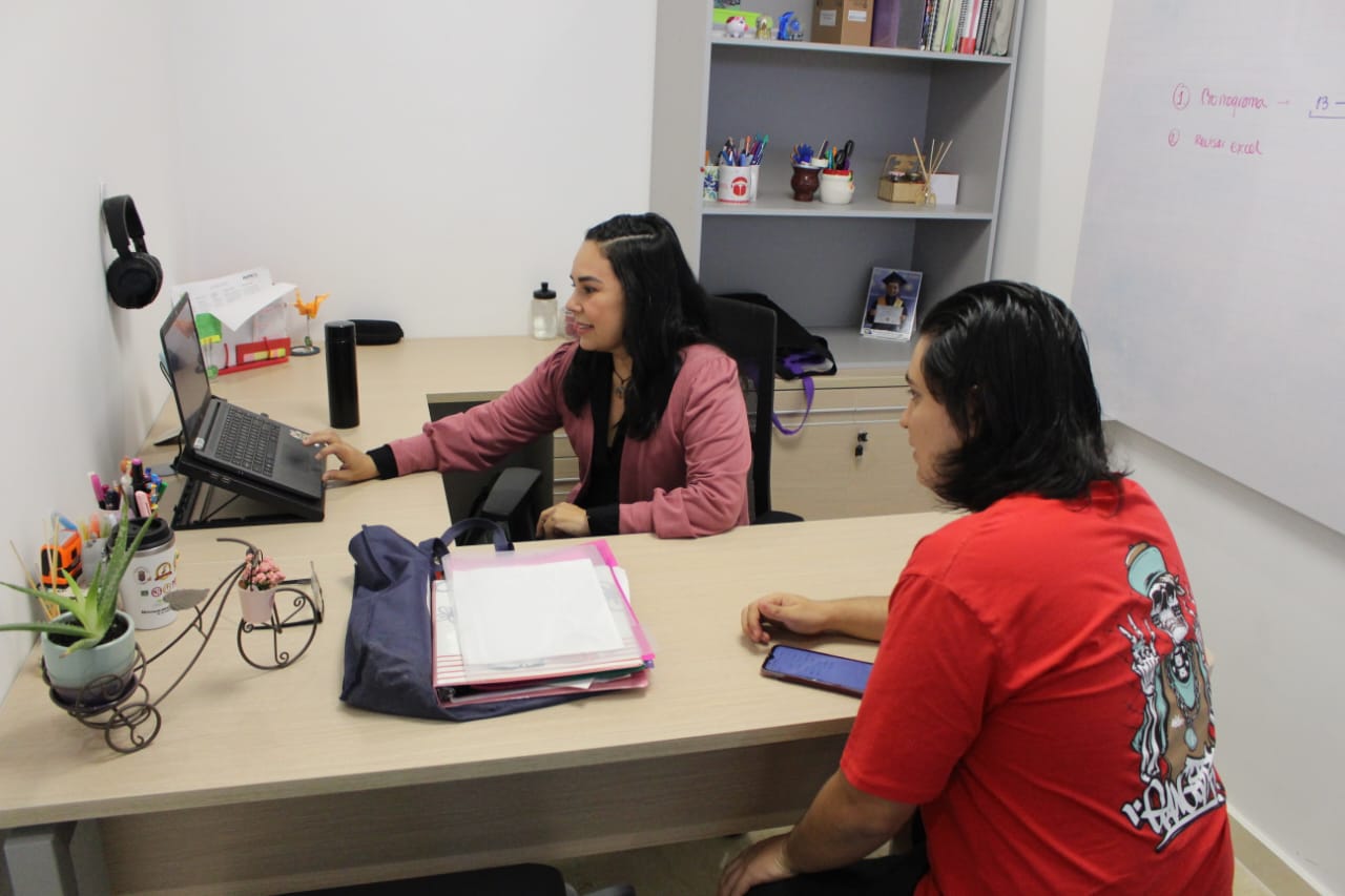 Imagen de una profesora de Matemáticas en asesoría con un estudiante.