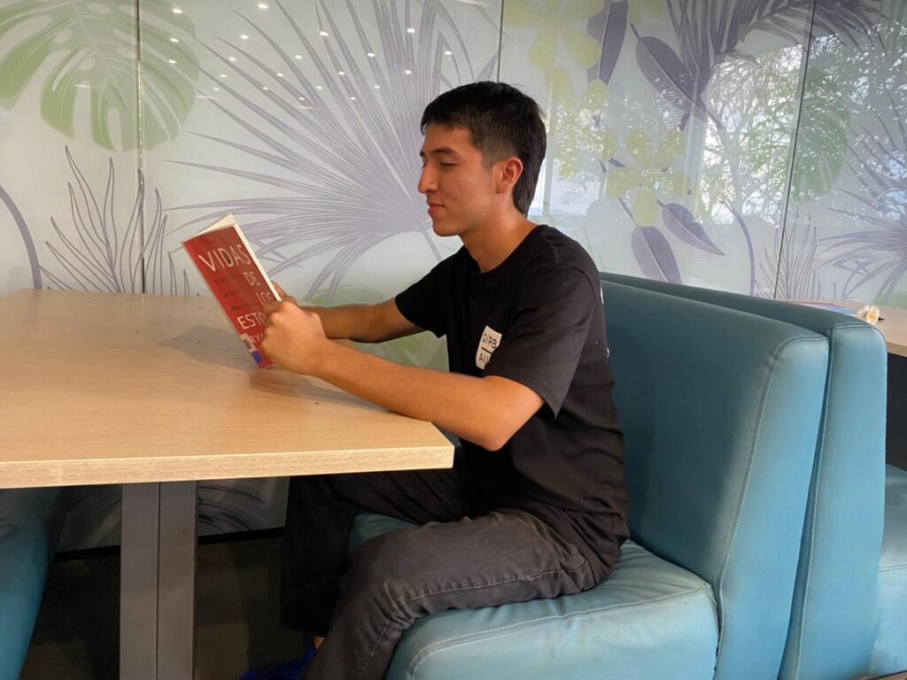 Estudiante leyendo un libro.