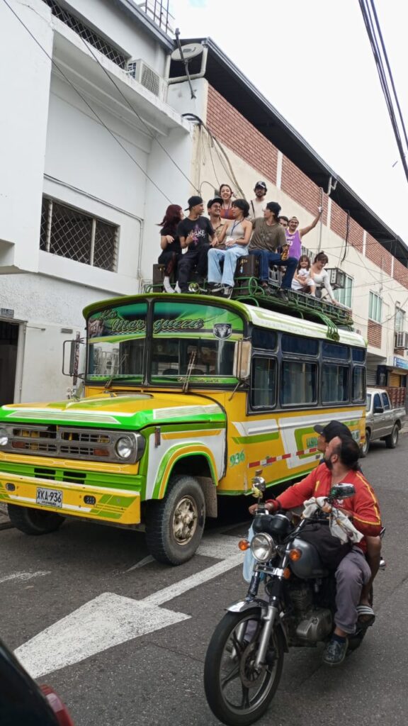Grupo de personas sobre un bus que transita por la calle