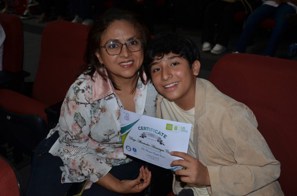 Mamá acompaña a niño en graduación UIS