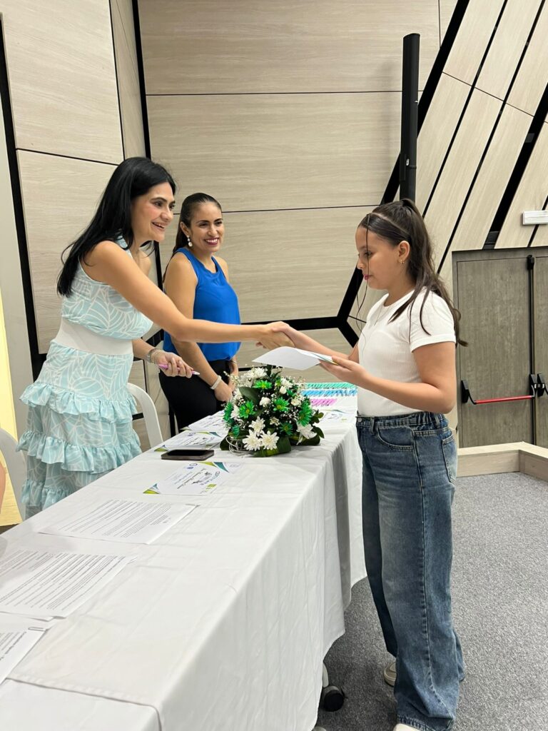 Niña recibe un diploma de graduación.