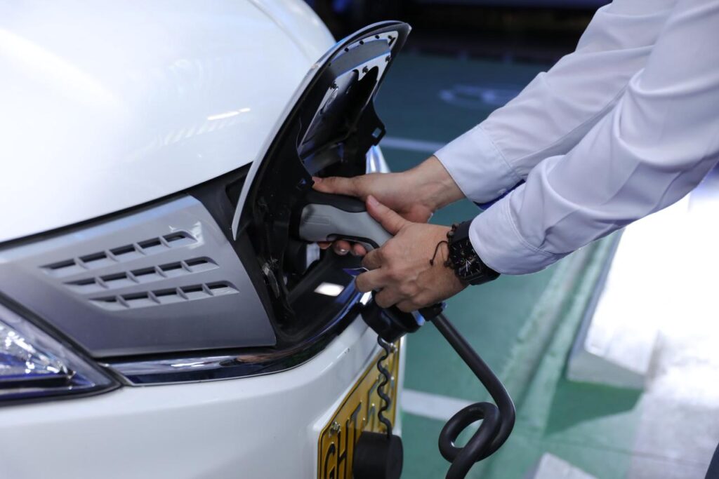 Persona conectando el carro para una carga eléctrica